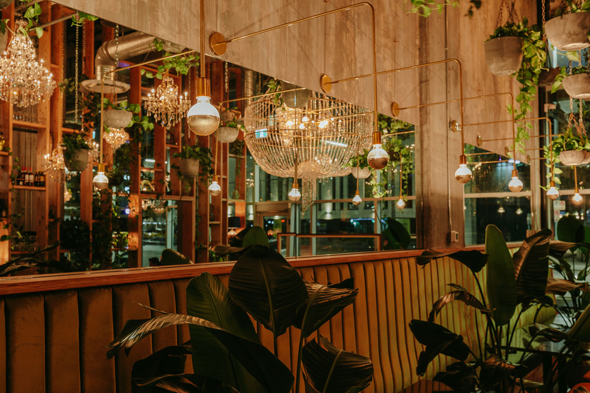 Orchard restaurant interior with plants and chandeliers